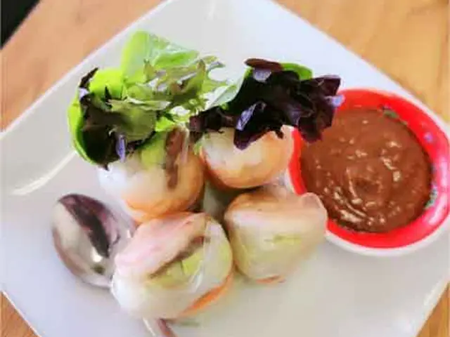 Fresh spring rolls in rice paper with herbs and vegetables.